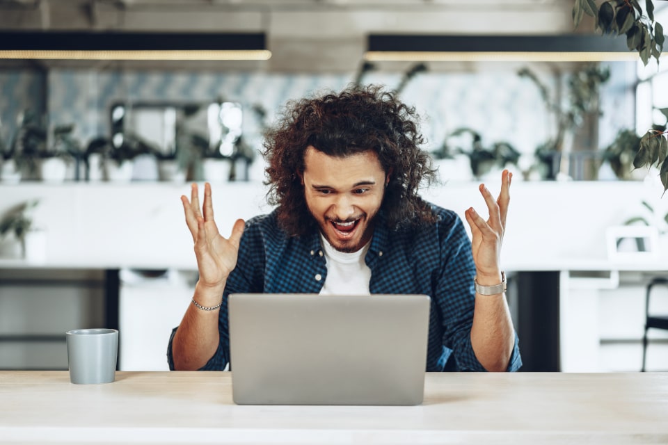 Upset man screaming at a laptop