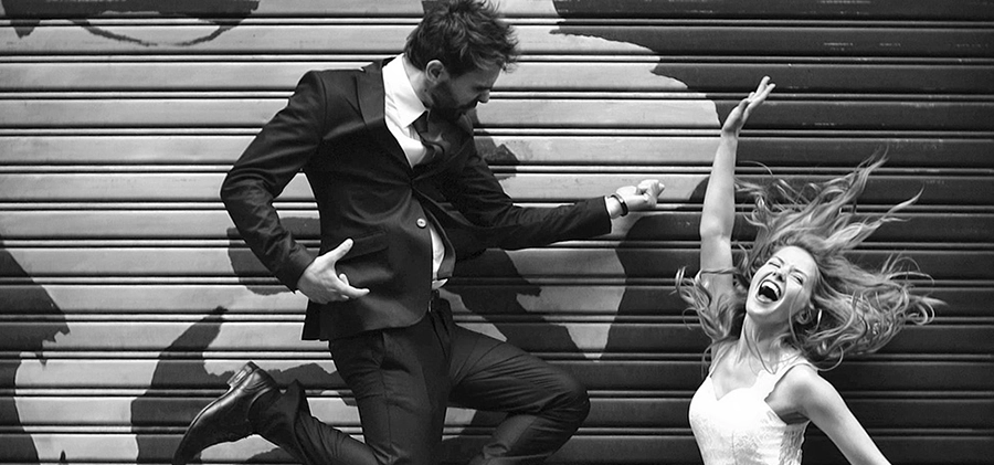 A groom and bride jumping in the air
