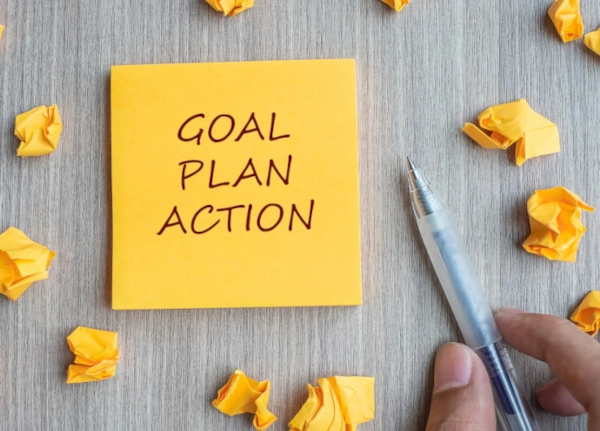 Goal, plan, action on a post it next to the hand of a person figuring out how to collaborate with influencers