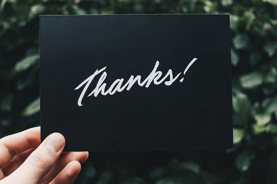 Someone holding up a Thanks! card