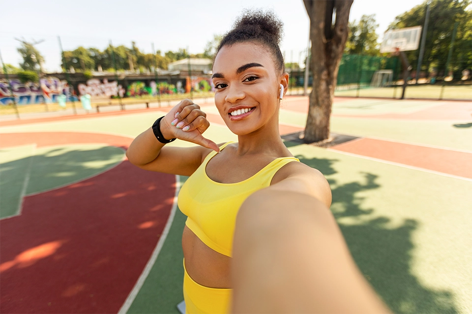 Woman in a yellow exercise outfit taking a selfie