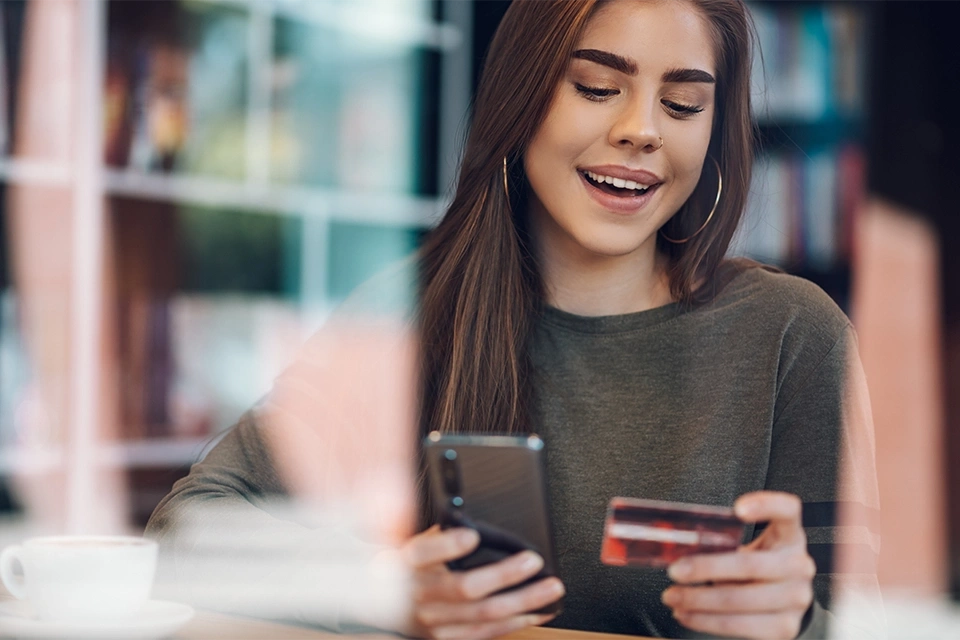 Woman ordering something on her phone showing retargeting is one of many ecommerce marketing strategies