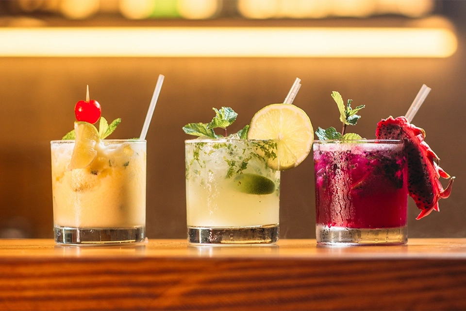 Three delicious-looking cocktails on a bar