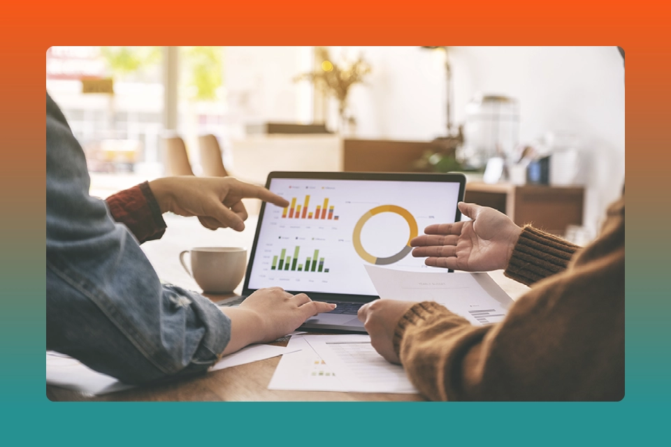 Two people looking at metrics, part of how to create a customer loyalty program