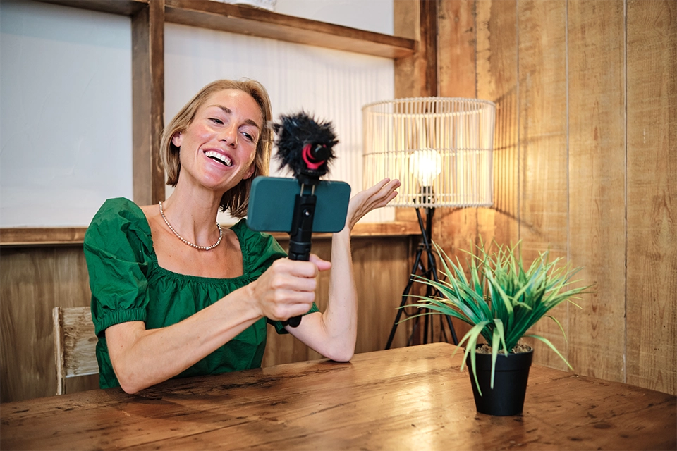 good influencer marketing resources include a way to help contact influencers like this woman recording a video at a table