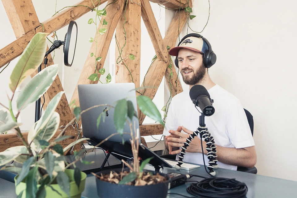 Lifestyle influencer recording with headphones on a laptop