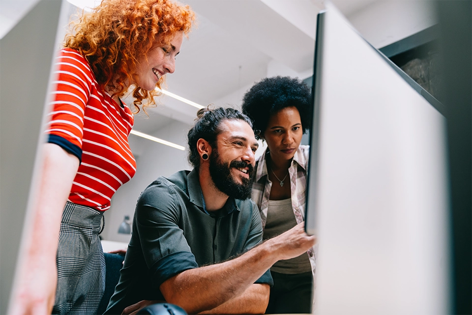 Three people looking at a computer monitor at a free influencer search tool