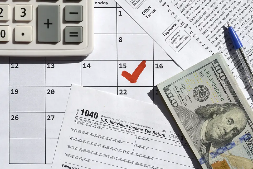 Image of tax day with dollars and tax forms