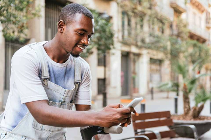 Man checking his phone and smiling, likely about his influencer rates approval