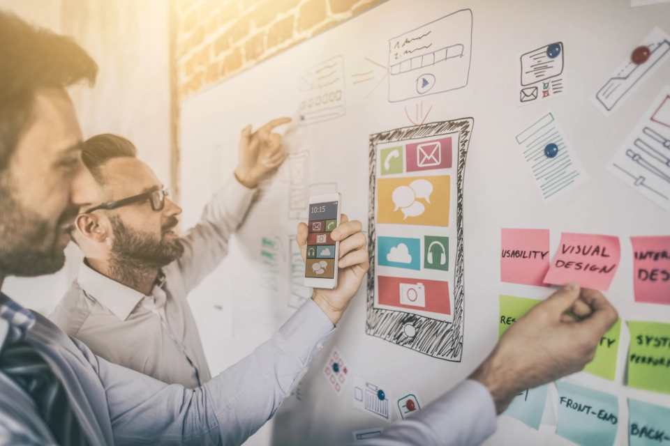Two coworkers planning on a whiteboard